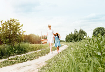 a walk along a country road, mom and daughter, a path in the field, years of a village. forest or outdoors park.