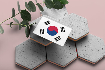 South Korea flag on hexagon stylish stones. Pink copy space background. Flat lay, top view minimal national concept.
