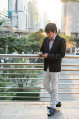 Korean Businessman using smartphone in city