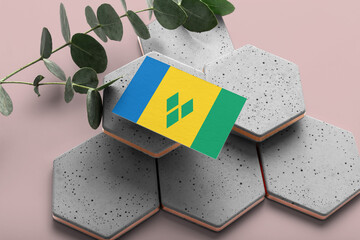 Saint Vincent And The Grenadines flag on hexagon stylish stones. Pink copy space background. Flat...