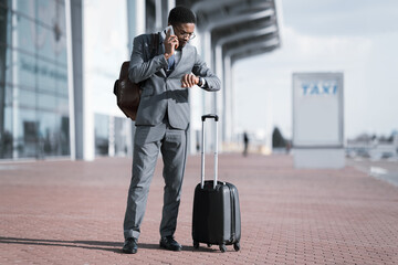 African Businessman Talking On Phone Waiting For Taxi Outside Airport