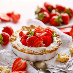 Tart with the addition of fresh strawberries and cream cheese, sprinkled with powdered sugar close up view