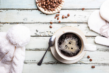 Top view cup of hot coffee with roasted coffee beans on wooden background. Winter composition.