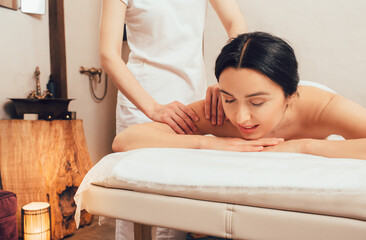 Obraz na płótnie Canvas Beautiful brunette enjoying a back massage in an oriental spa salon. Thai body massage