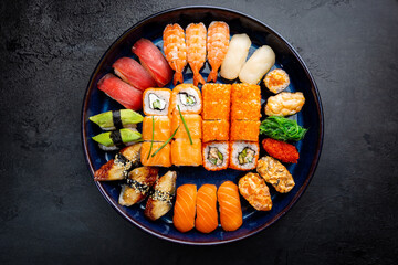 Fototapety  Zestaw sushi i maki z sosem sojowym na czarnym tle. Widok z góry z miejscem na kopię