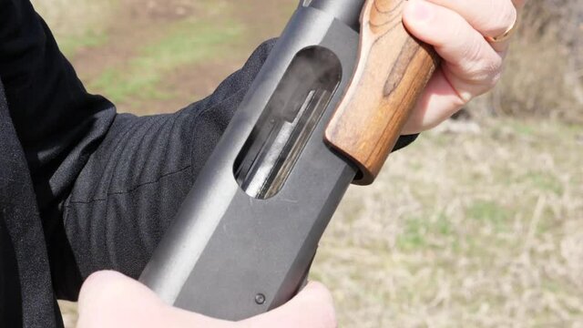 Man pumps shotgun shell and smoke come out.