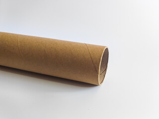 One long cardboard sleeve, pipe on a white background. Recycled beige cardboard cylinder against the background of an empty place for text.