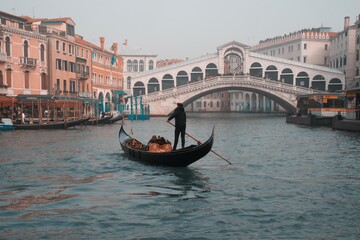 Gondolier floats on the Grand Canal in foggy weather