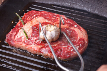 ribeye beef steak frying in grill pan