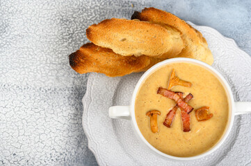 Mushroom, chanterelle cream soup with becon on light background, selective focus