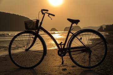Fototapeta na wymiar silhouette of bicycle at beach, bicycles on beach sunset or sunrise