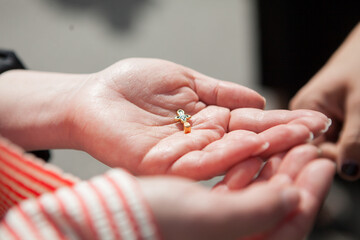 Female hands hold christian cross before baptism ceremony