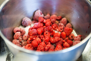 Fresh raspberries with sugar in a metal saucepan