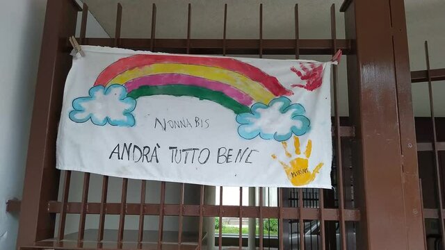 Turin, Piedmont, Italy. June 2020. Coronavirus pandemic. On the facades of the houses hang the sheets with the drawing of the rainbow and message everything will be fine. In Italian "Andr&agrave; tutto bene"