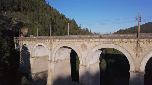 Aerial view of freight train rides on famous Kalte Rinne Viaduct on historical Semmering mountain railway (Semmeringbahn), Lower Austria.