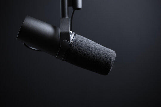 Black podcasting microphone on black background