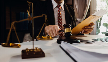 Business and lawyers discussing contract papers with brass scale on desk in office. Law, legal...