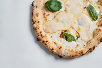Italian pizza with cheese and basil on a white background. Copyspace.
