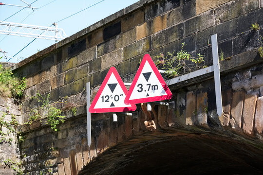 Bridge height restriction sign under railway train track