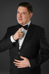 Portrait of an attractive young businessman in black background wearing suit and necktie. Classic style. Studio shot