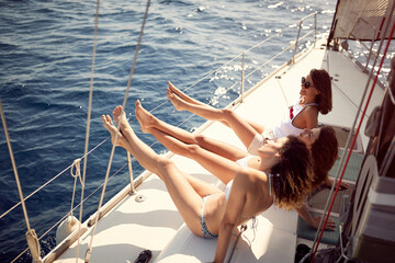 Girls sailing on yacht. Vacation, travel, sea, friendship and people concept.