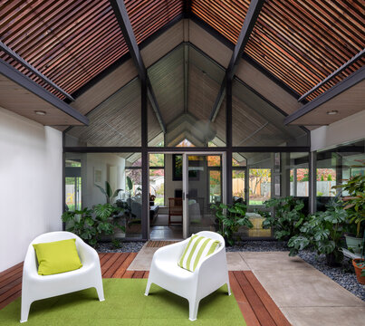 Modern Living Room That Is Bright And Airy With Lots Of House Plants, Slanted Roof