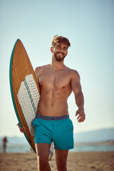 Young man going to surfing on the beach.Man with  surfboard at summer.