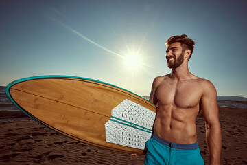 Handsome Man surfer on a beach. Smiling  man go to surfing.