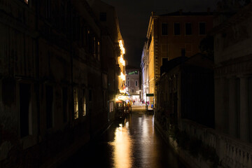 Long exposed image of a street and canal at night in Venice / Italy