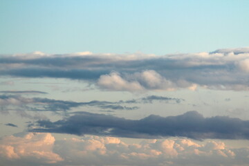 White fluffy clouds on a background of blue sky in summer. The concept of weather and climate