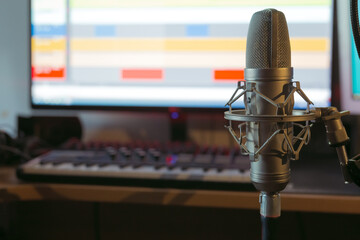 professional microphone at the recording studio, in the background in the blur of the workplace of...
