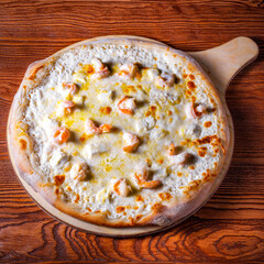 Delicious round pizza on a wooden stand on the table