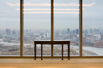 View of London and Thames River  through office building windows with table in foreground