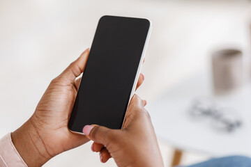 Mockup of smartphone with black screen in hands of unrecognizable black woman