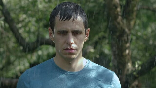 Sad man stands in the rain