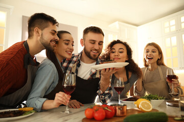 Happy people with delicious food in kitchen. Cooking class