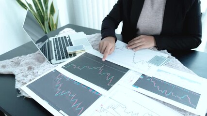 Young women sitting at a desk with a laptop, stock chart and cards, Don't play stock share like gambling concept. - Powered by Adobe