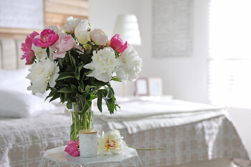 Beautiful blooming peonies on table in bedroom. Space for text