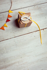 Kommunion, Konfirmation, Firmung, Taufe, Glaube - kleines Geschenk mit gelbem Band auf hellem Holz...