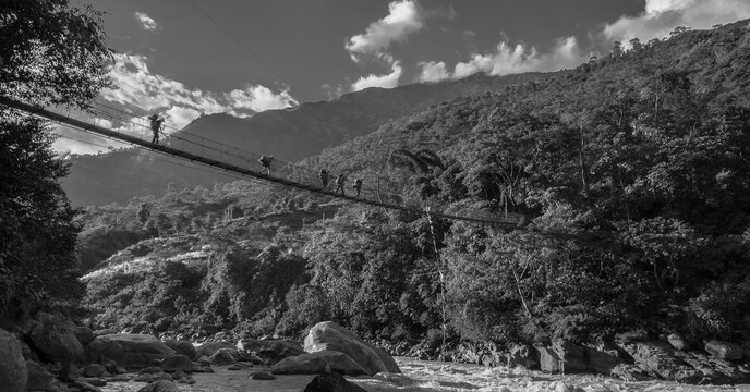 A group of trekkers crossing the suspension bridge ove Marshyangdi river and their way to Bhulbhule village and Besi Sahar village, Nepal, Nepal Himalayas