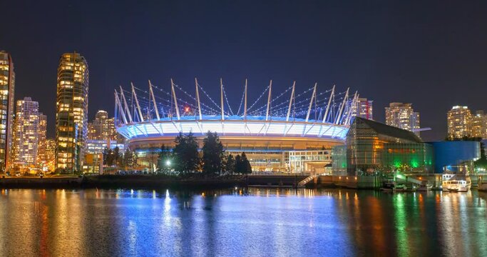 Panning time lapse shot of illuminated BC Place by sea against sky at night - Vancouver, Canada