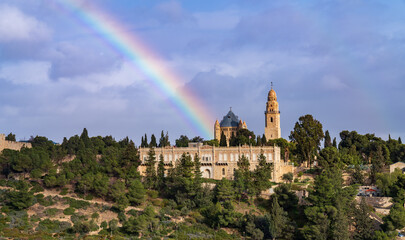 Obraz premium View on the Dormition Abbey, mount Zion, old city of Jerusalem with a rainbow. Israel.