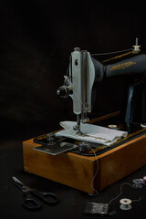 Sewing machine and parts on a dark background.