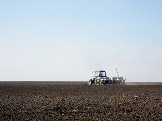 Fototapeta premium Plowed field by tractor in brown soil on open countryside nature