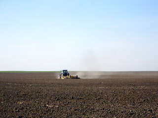 Plowed field by tractor in brown soil on open countryside nature