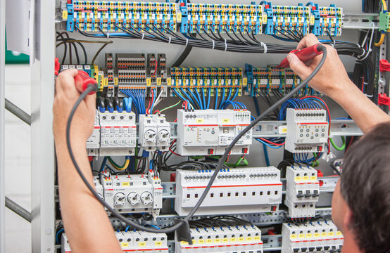 Ein Elektriker misst die Spannung in einer elektrischen Anlage