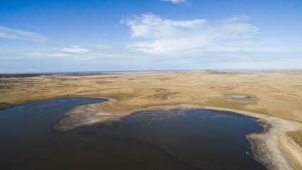 Countryside scenic. Aerial view of the golden prairie, coastline and lake in autumn.