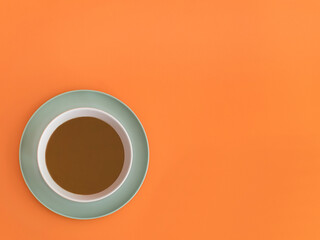 Chocolate bowl on a orange background. Copy space.