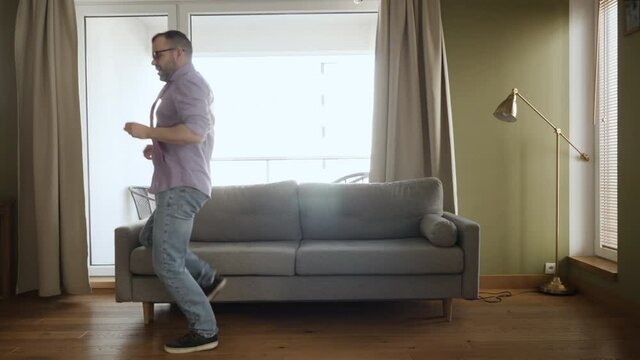 Man Dancing at Home Living Room, Fun Celebrating Funny Viral Dance Freedom Weekend. Happy Young Guy Enjoying Shuffle Dance, Having Fun Party. Joyful Man Dancing Cheerful In Living Room. Happy People.