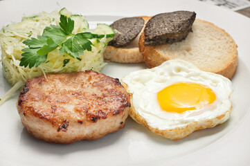 The idea of breakfast. Fried eggs with cutlet and salad